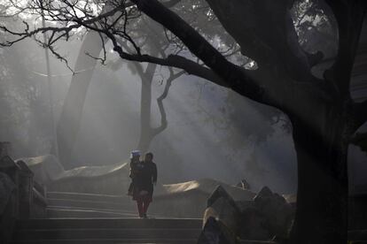 Una mujer con su hijo camina por las instalaciones del templo de Pashupatinath durante el festival Swasthani Brata Katha en Katmandú (Nepal).