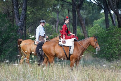 Dos peregrinos a caballo se dirigen durante la romería hacia la aldea almonteña de El Rocío (Huelva), el miércoles.