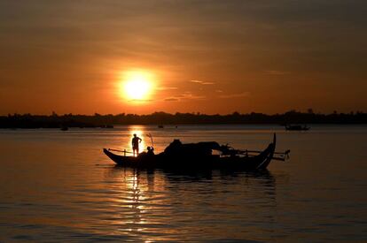 Un pescador lanza sus redes de pesca desde un barco en el río Mekong, situado en Phnom Penh (Camboya).