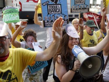Afectados por las preferentes convocados por Adicae protestan ante la sede de Bankia en Valencia.