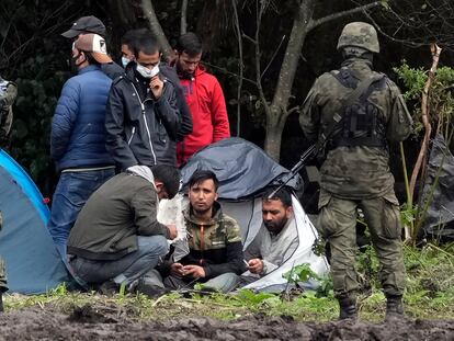 Soldados polacos vigilan a un grupo que forma parte de un campamento de 32 afganos atrapados en tierra de nadie entre la frontera de Polonia y Bielorrusia, el pasado 1 de septiembre en Usnarz Gorny.