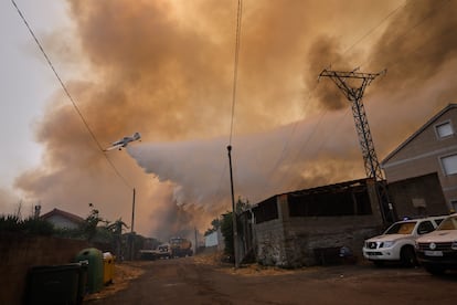 Un avión de extinción de incendios lanza agua sobre el incendio forestal en Veiga das Meas, el sábado.