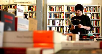 Un cliente hojea un libro en una librería.
