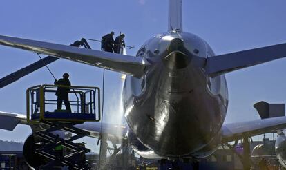 Varios operarios lavan un avión Boeing.