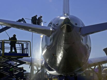 Varios operarios lavan un avión Boeing.