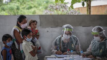 Health workers vaccinate a mother and her children in Manaos, Brasil.