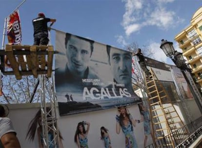 Dos operarios colocaban ayer un cartel del Festival de Málaga.