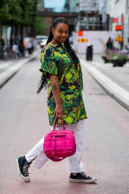 Maxitop + pantalón blanco + Converse. Esta opción convierte el estampado tropical en el protagonista del look (con permiso del bolso acolchado de Prada). La amplitud de las prendas es clave para lograr un resultado confortable.