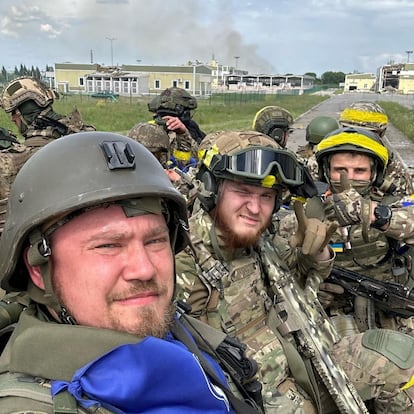 Miembros del Cuerpo de Voluntarios Rusos posan sobre un vehículo blindado en el cruce fronterizo de Graivoron en Kozinka, en la región fronteriza rusa de Bélgorod, en una foto distribuida este martes.