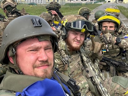 Miembros del Cuerpo de Voluntarios Rusos posan sobre un vehículo blindado en el cruce fronterizo de Graivoron en Kozinka, en la región fronteriza rusa de Bélgorod, en una foto distribuida este martes.