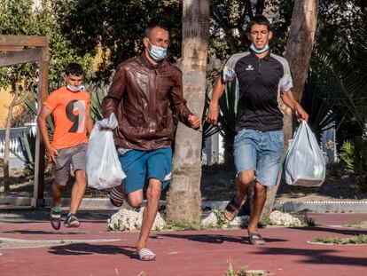 Tres marroquíes que viven en las calles de Ceuta huyen de una redada policial, el pasado 23 de mayo.