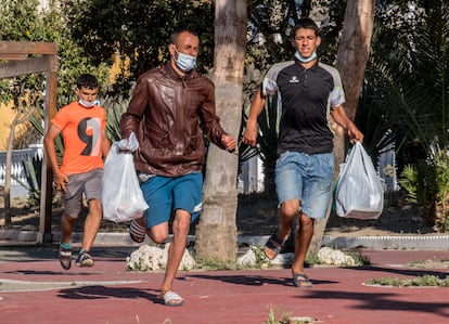 Tres marroquíes que viven en las calles de Ceuta huyen de una redada policial, el pasado 23 de mayo.