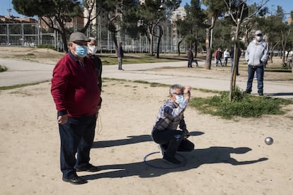 Un jugador realiza su lanzamiento durante una partida de petanca en el parque de Aluche.