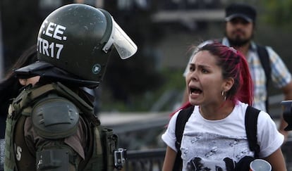 Uma manifestante discute com um carabineiro nos protestos de Santiago.