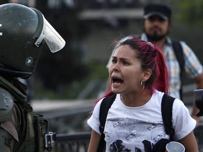 Una manifestante discute con un carabinero en las protestas de Santiago de Chile.