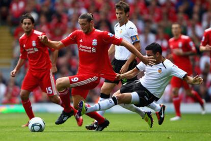 Rami, defensa del Valencia, comete falta ante Carroll, del Liverpool, ayer en Anfield.