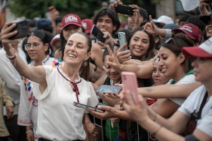 Claudia Sheinbaum se toma una fotografía con un grupo de seguidores. 