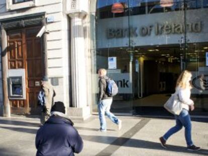 Un hombre pide limosna en Dublín frente a una sucursal del Banco de Irlanda.