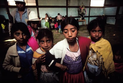 Mayan girls look over the foreign photographer in a community hall during a party to celebrate the arrival of electricity to a small settlement near Todos Santos Cuchumatan in the Cuchumatan Mountains in the Western Highlands of Guatemala