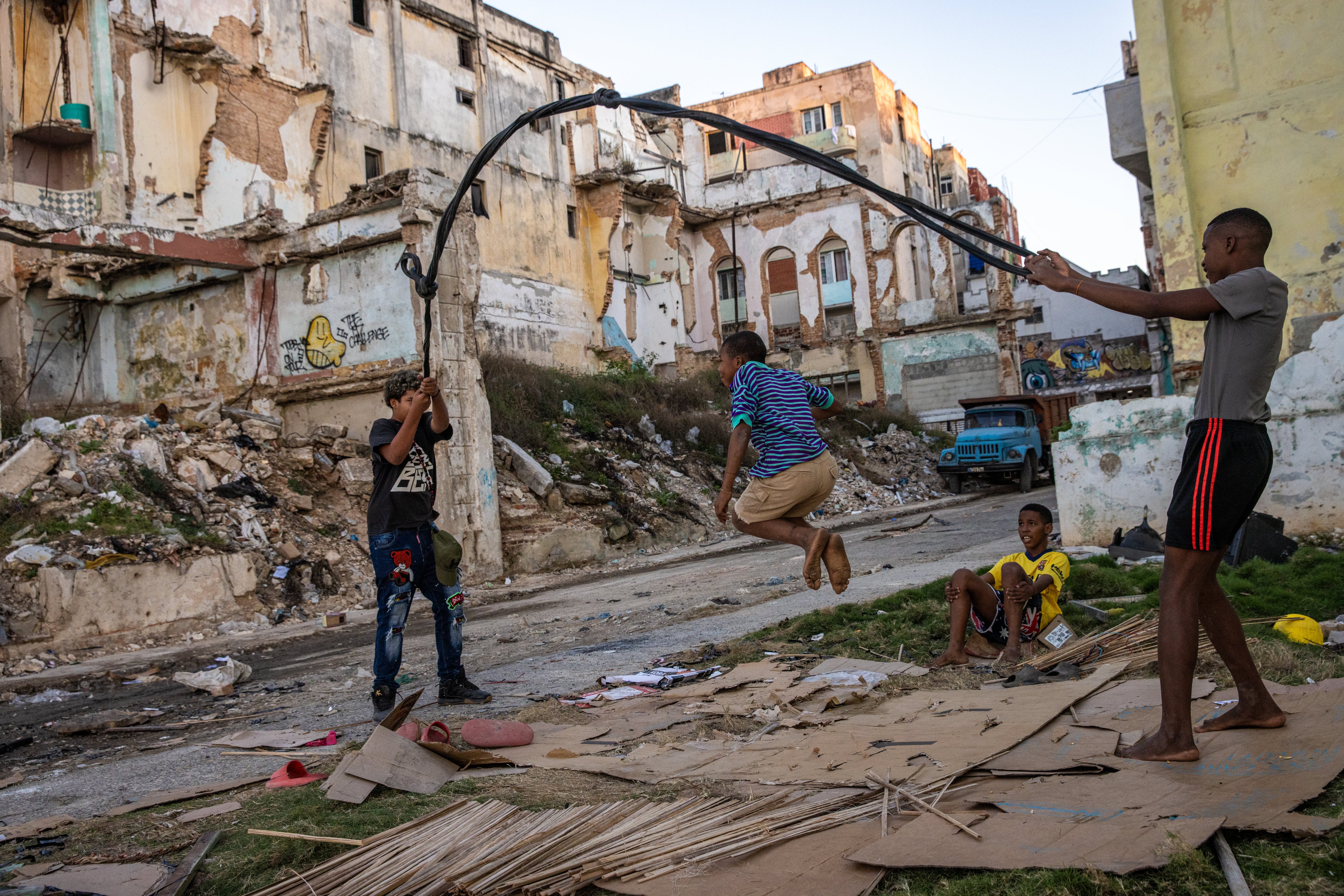 Unos niños juegan con un cable reciclado entre las ruinas y los escombros de La Habana, en Cuba, el 29 de diciembre de 2025.