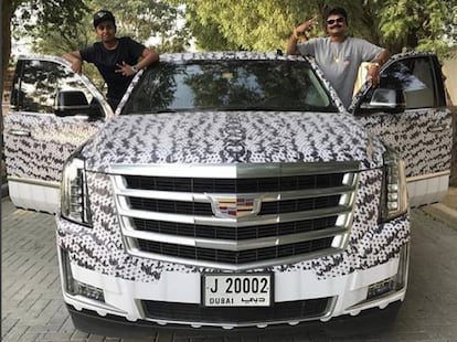 Rashed Belhasa (izquierda), de 15 años, posa junto a un amigo subido a uno de los coches de lujo de su familia.