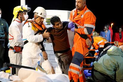 Un joven es ayudado por miembros de Salvamento Marítimo a su llegada al puerto de Melilla, en noviembre de 2019.