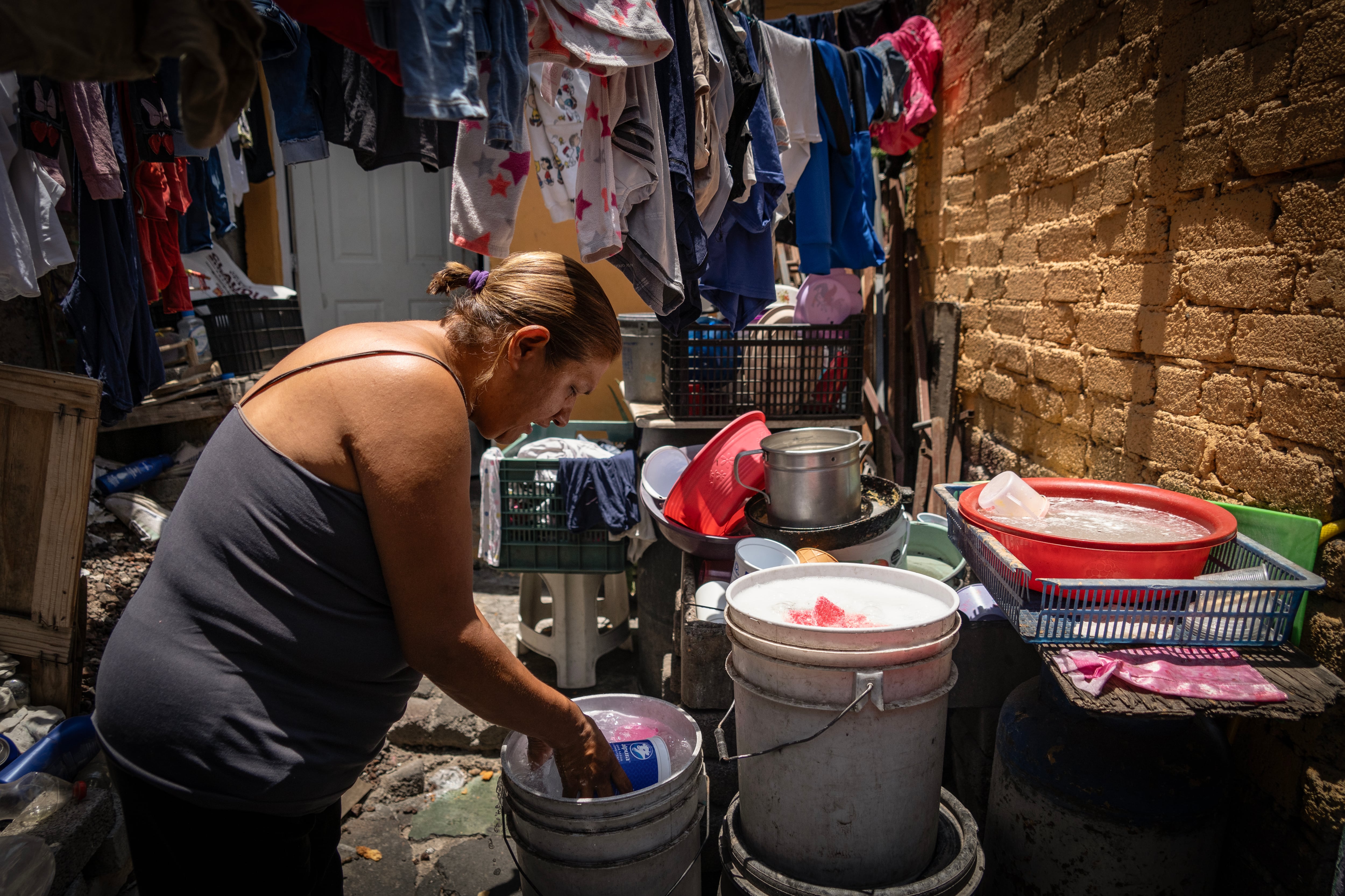 Elizabeth Pinzón Ramírez muestra el agua que almacena en cubetas en su hogar, debido a la escasez de agua que vive junto a miles de pobladores de la alcaldía Iztapalapa, el 11 de junio de 2024. 