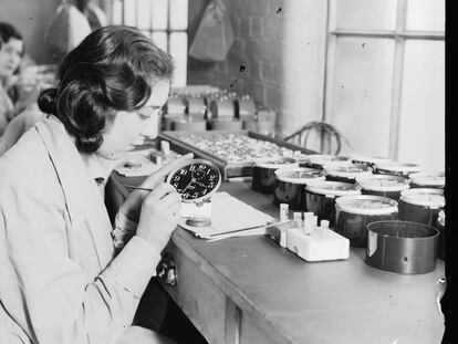 Uma trabalhadora emprega pintura luminosa em uma fábrica de relógios em 1932.