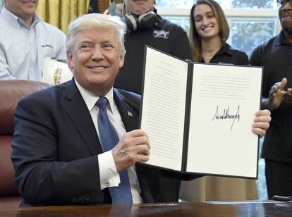 Donald Trump muestra uno de sus documentos ejecutivos, recién firmado.