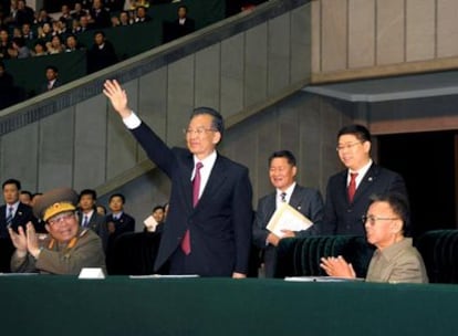 El líder norcoreano, Kim Jong-il (sentado a la derecha), y el primer ministro chino, Wen Jiabao (de pie), durante un acto organizado con ocasión de la visita de este último a Pyongyang.