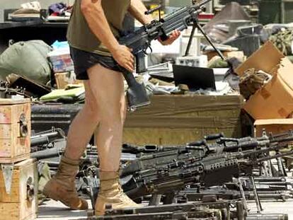 Un<i> marine</i> comprueba su arma antes de entregarla, una vez que ha terminado su periodo militar en Irak.