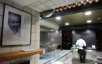 Vista de la cocina del restaurante Can Fabes de Sant Celoni, presidida por una gran fotografía del malogrado cocinero catalán Santi Santamaría, que cerrará sus puertas el próximo 31 de agosto.