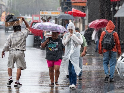 Personas caminan con paraguas e impermeables bajo la lluvia en Monterrey (Nuevo León), el 19 de junio.