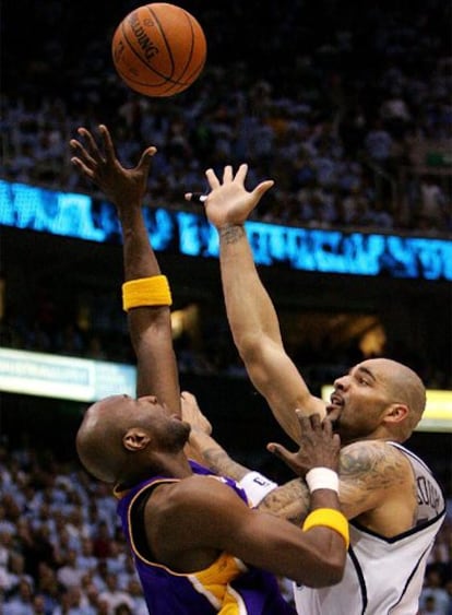 Boozer, de Utah, lanza a canasta ante Odom, de los Lakers.