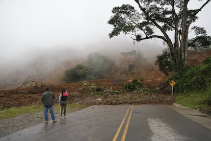 Dos personas observan una carretera bloqueada tras el derrumbe en Rosas, departamento del Cauca (Colombia) que dejó más de 900 personas afectadas