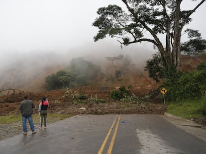 Dos personas observan una carretera bloqueada tras el derrumbe en Rosas, departamento del Cauca (Colombia) que dejó más de 900 personas afectadas