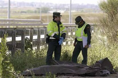 Dos agentes de la Guardia Civil junto a los cuerpos de los fallecidos en el accidente de Getafe (Madrid).