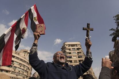 Un manifestante porta un Corán y un crucifijo durante una manifestación en la plaza de la Revolución (Tahrir). Detractores y seguidores del presidente Morsi han salido a la calle tras los poderes que se otorgó ayer.