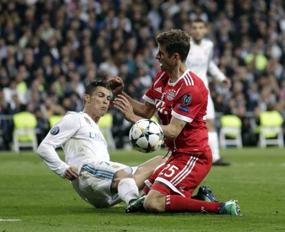 Cristiano Ronaldo disputa un balón en el suelo a Müller.