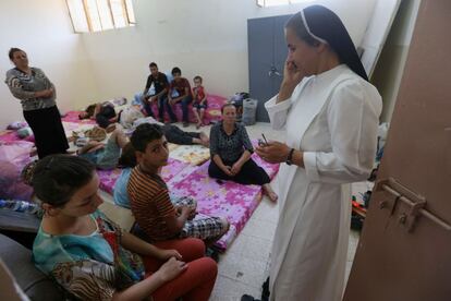 Una monja iraquí habla a través del teléfono móvil en un momento de su visita a las familias desplazadas que han huido de los pueblos de mayoría cristiana de la provincia de Mosul.