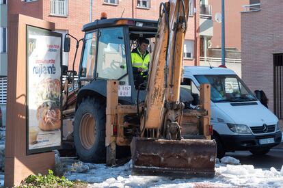 A Madrid city worker clearing a street of snow and debris to prevent flooding ahead of rains expected later this week.