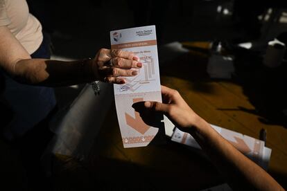 Para estos comicios, el Tribunal Superior de Justicia Electoral ha instalado 12.259 mesas de votación y ha llamado a 36.777 funcionarios. En la imagen, una mujer se prepara para depositar su voto en una de las urnas de un colegio en Asunción.