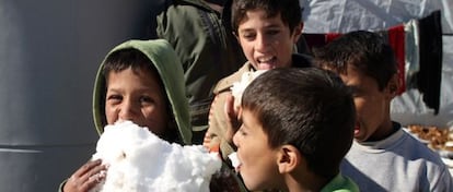 Crianças brincam com neve em um campo de refugiados no Líbano.