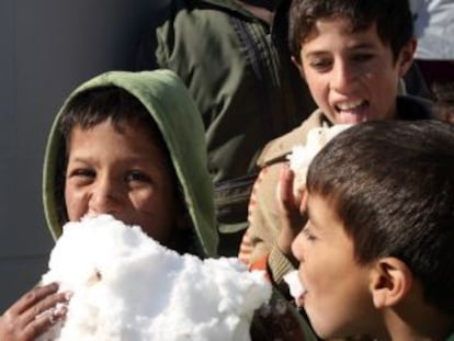 Ni&ntilde;os sirios juegan con nieve en un campo de refugiados en L&iacute;bano.
