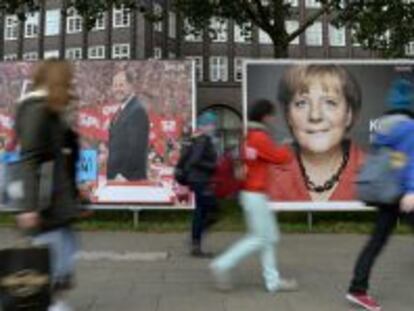 Jóvenes alemanes pasan por delante de carteles electorales del candidato socialista, Peer Steinbrueck, y de la canciller alemana, Angela Merkel.
