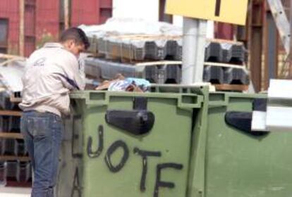 Un joven busca en un contenedor de basura algo de comida. EFE/Archivo