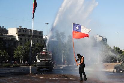 Un manifestante sostiene una bandera de Chile en una protesta en Santiago el 30 de octubre 2020.