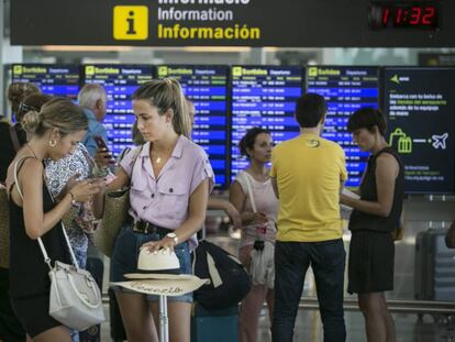 Viajeros en el aeropuerto de El Prat esperan junto al punto de facturación de Vueling