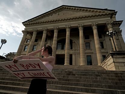 Zoe Schell, from Topeka, Kansas, stands on the steps of the Kansas Statehouse during a rally to protest the Supreme Court's ruling on abortion in June 2022.