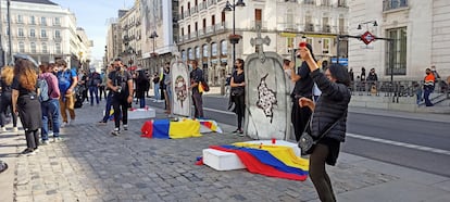 Los manifestantes despliegan dos lápidas en la Puerta del Sol de Madrid para protestar por la violencia de Estado y policial en su país, Colombia.